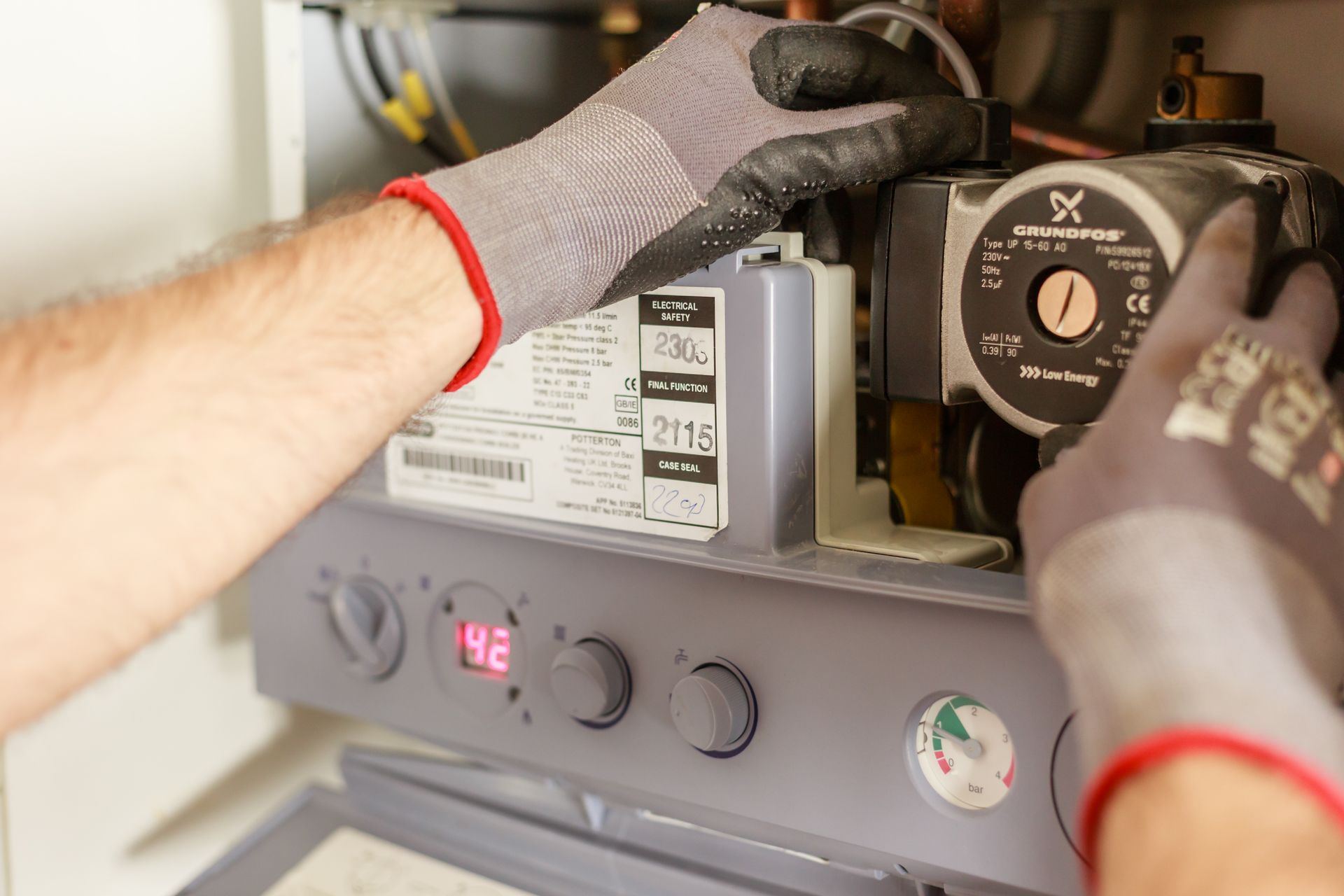Manos con guantes trabajando en el interior de un electrodoméstico